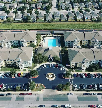 Aerial view of asphalt maintenance using sealcoat and striping applied to a parking lot