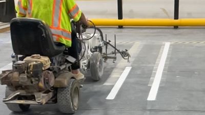 Construction worker restripes pre-existing warehouse lot lines