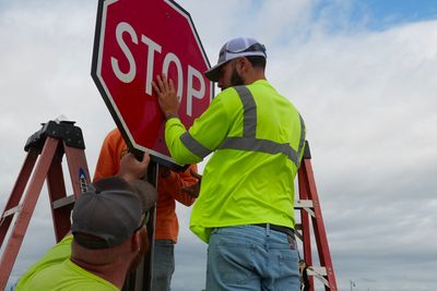 A Stripe-It-Up crew installing a stop sign