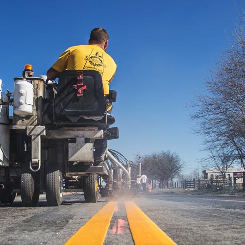 A Stripe-It-Up crew member applies double yellow lane markings